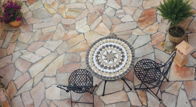 Terrasse mit Gartenmöbeln auf Naturstein