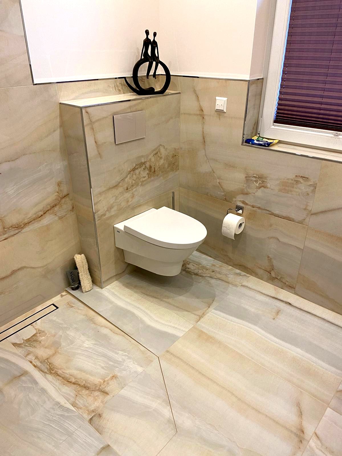 Wand-WC vor durchgehender Onyx-Großformatwand